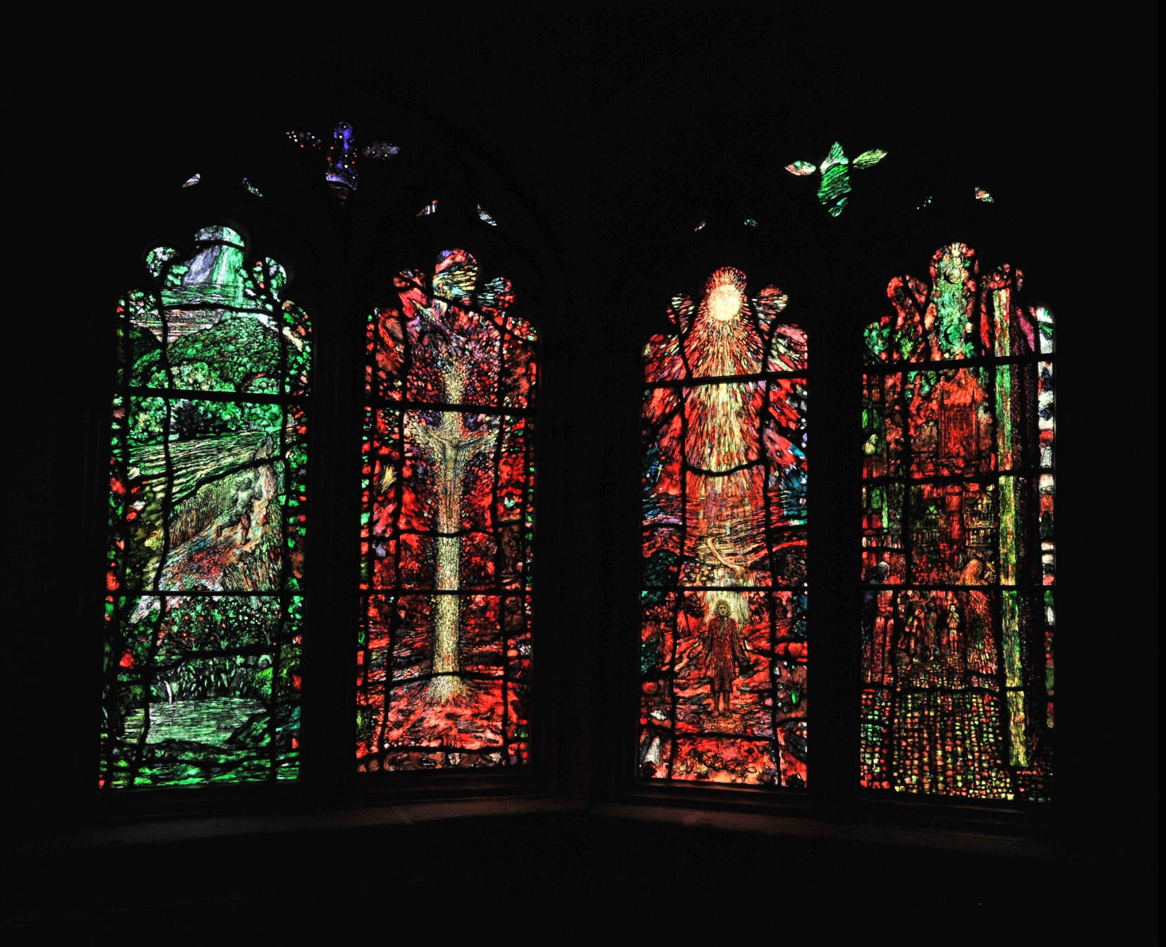The Traherne Windows - four brightly coloured panels which look as if they are covered in illustrations