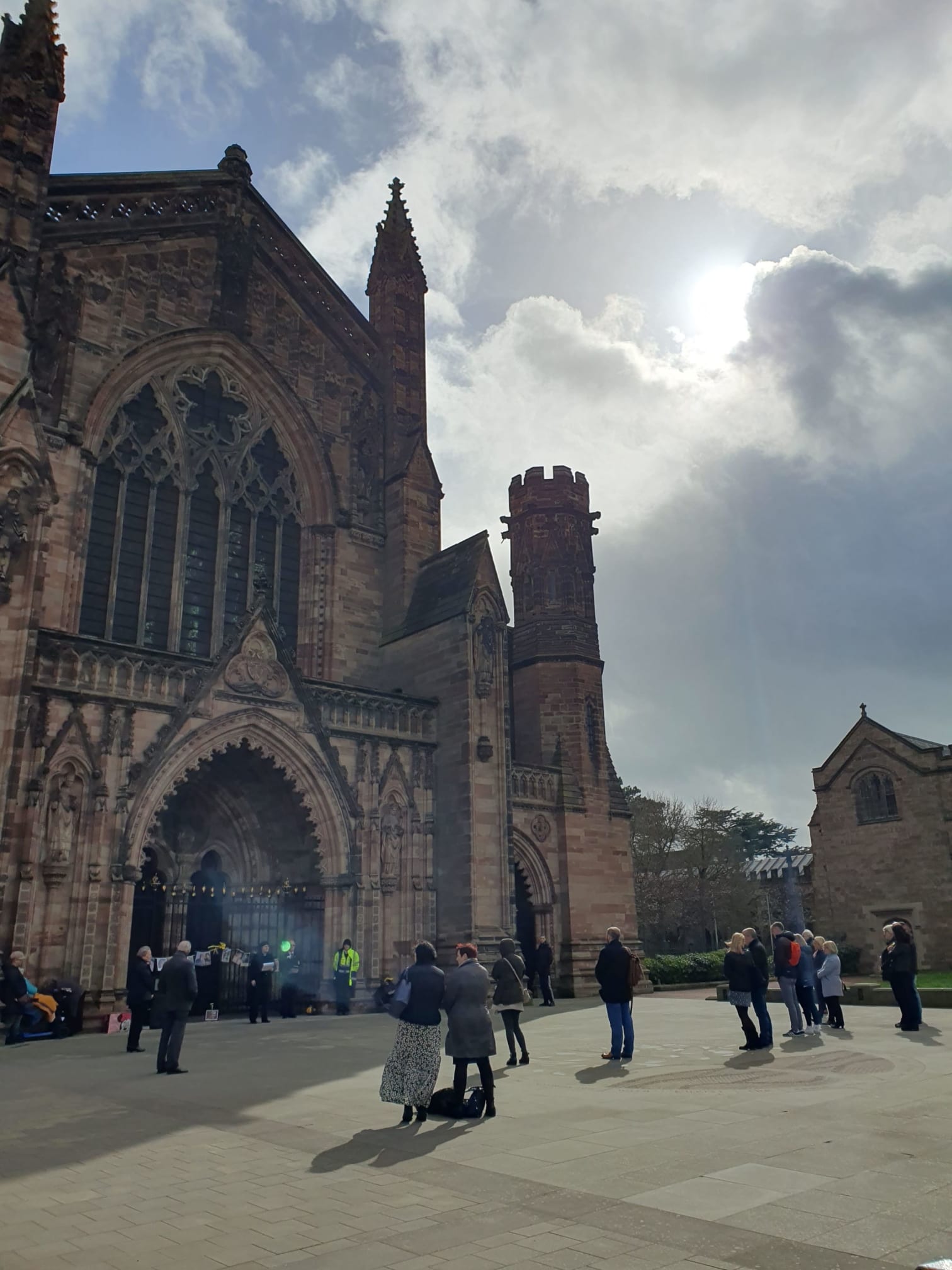 The sun breaks through the clouds above the West End of the cathedral
