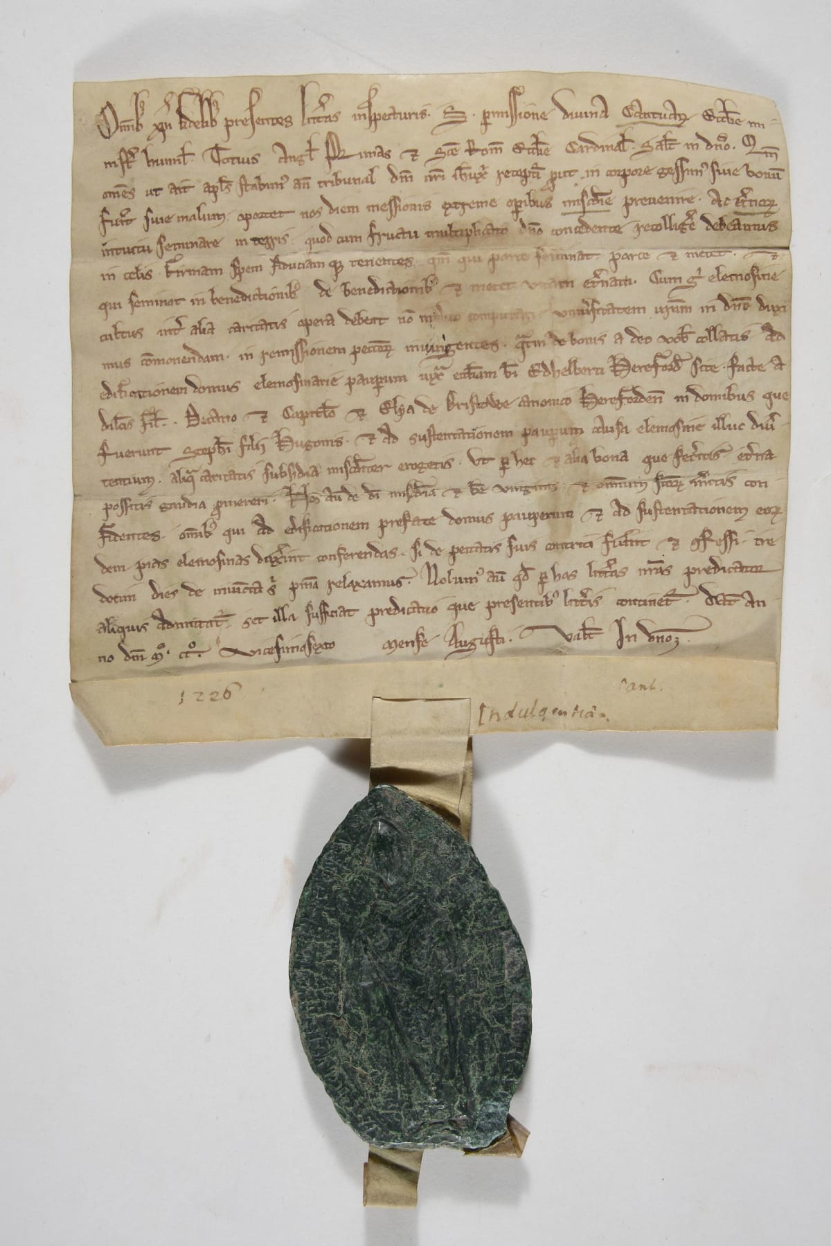 •	A square-shaped document, written on parchment, with a green lozenge-shaped seal attached to the centre of its base.