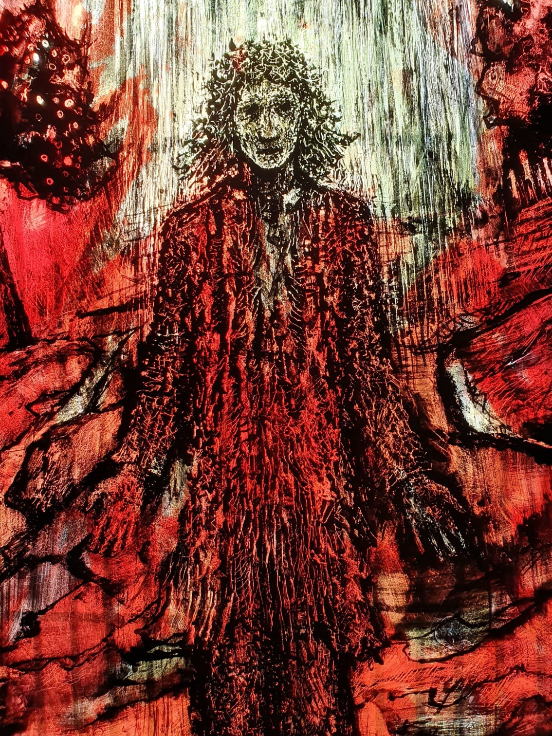 A close up of an illustration of a man, possibly Traherne, in the glass. The background is red and orange and the man is holding his palms outwards